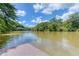 Peaceful river view showing a wooden dock and lush green forest on the opposite riverbank at 200 Rivermere Way, Sandy Springs, GA 30350
