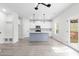 Bright open-concept kitchen features white cabinets, stainless appliances, blue island and light wood floors at 2949 Jefferson St, Austell, GA 30106
