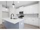 Modern kitchen with white cabinets, stainless appliances, quartz countertops, a blue island and pendant lighting at 2949 Jefferson St, Austell, GA 30106
