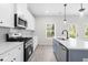 Kitchen featuring stainless steel appliances, white cabinets, quartz countertops and a blue island with sink at 2949 Jefferson St, Austell, GA 30106
