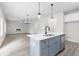 Open-concept living space with light wood floors, fireplace, modern chandelier, and view of the kitchen island at 2949 Jefferson St, Austell, GA 30106