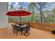 Back deck has an outdoor table with seating under a large red umbrella at 525 Water Shadow Ln, Alpharetta, GA 30022
