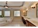 Luxurious bathroom with a soaking tub, dual sinks, and elegant lighting fixtures at 525 Water Shadow Ln, Alpharetta, GA 30022