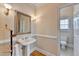 Charming half bath with pedestal sink, gold accents, and view into the full bath at 525 Water Shadow Ln, Alpharetta, GA 30022