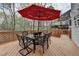 Outdoor deck featuring a glass-topped dining table with seating and a red umbrella at 525 Water Shadow Ln, Alpharetta, GA 30022