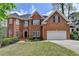 Charming two-story brick home with a well-manicured lawn and attached two-car garage at 525 Water Shadow Ln, Alpharetta, GA 30022