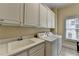 Bright laundry room with a sink, white cabinets, and modern washer and dryer at 525 Water Shadow Ln, Alpharetta, GA 30022