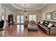 Open-concept living room with hardwood floors, a leather couch, and large windows providing natural light at 525 Water Shadow Ln, Alpharetta, GA 30022