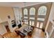 Aerial view of a grand living room with hardwood floors, fireplace, large windows, and stylish furnishings at 525 Water Shadow Ln, Alpharetta, GA 30022