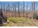 A backyard featuring a green lawn with a forested backdrop and staircase at 760 Valley Summit Drive, Roswell, GA 30075