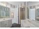 Bathroom featuring dual vanities, decorative wallpaper, and a glass-enclosed shower at 760 Valley Summit Drive, Roswell, GA 30075
