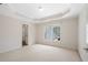Light-filled bedroom with tray ceiling, carpet, and a large window at 760 Valley Summit Drive, Roswell, GA 30075