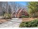 Exterior of the home featuring brick facade, dormer windows, manicured landscaping, and a paved driveway at 760 Valley Summit Drive, Roswell, GA 30075