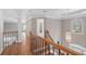 Hallway with hardwood floors, iron railing, arched window, and pendant lighting at 760 Valley Summit Drive, Roswell, GA 30075
