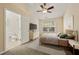 Cozy staged bedroom with carpet, ceiling fan, neutral walls, window, and an open ensuite bathroom at 1536 Liberty Nw Pkwy, Atlanta, GA 30318