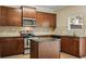Kitchen featuring granite countertops, stainless steel appliances, wood cabinets, and a center island at 1536 Liberty Nw Pkwy, Atlanta, GA 30318