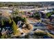 Aerial view of a brick home near a shopping center and surrounded by lush trees at 4129 Lansfaire Ter, Suwanee, GA 30024