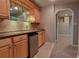 Home bar area with light wood cabinetry, granite countertop, mini fridge and backsplash at 4129 Lansfaire Ter, Suwanee, GA 30024