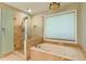 Relaxing bathroom with a separate glass shower and a luxurious soaking tub under a window at 4129 Lansfaire Ter, Suwanee, GA 30024