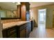 Bathroom with a large mirror, double sinks, dark cabinets, tile floor, and granite countertops at 4129 Lansfaire Ter, Suwanee, GA 30024