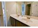 Bathroom with double sinks, granite countertop, brown cabinets, tile floor, and a large mirror at 4129 Lansfaire Ter, Suwanee, GA 30024