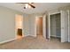 This neutral bedroom features a ceiling fan, an ensuite bathroom, and a closet with shelving at 4129 Lansfaire Ter, Suwanee, GA 30024
