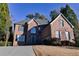 Beautiful brick two-story home with a well-maintained lawn on a sunny day at 4129 Lansfaire Ter, Suwanee, GA 30024