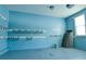 Bright blue garage with storage racks, a window, and visible garage door hardware at 4129 Lansfaire Ter, Suwanee, GA 30024