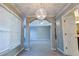 Hallway view with an arched entrance, a modern chandelier, a window, and doorways at 4129 Lansfaire Ter, Suwanee, GA 30024