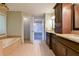 Luxurious bathroom featuring a tub, dual vanities, tile floor and brown cabinets at 4129 Lansfaire Ter, Suwanee, GA 30024