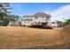 Large backyard featuring a spacious lawn, a deck, and well-maintained landscaping at 5292 Candleberry Sw Dr, Lilburn, GA 30047