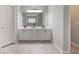 Elegant bathroom featuring a double sink vanity with white cabinets and marble-look tile floors at 5292 Candleberry Sw Dr, Lilburn, GA 30047