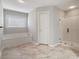 Bathroom showcases a bathtub, a large shower, and marble-look tile flooring and a large window at 5292 Candleberry Sw Dr, Lilburn, GA 30047