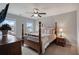 Spacious bedroom featuring a four-poster bed, windows, ceiling fan, dresser, and bedside table at 5292 Candleberry Sw Dr, Lilburn, GA 30047