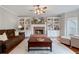 Inviting living room with a brick fireplace, built-in shelving, and hardwood floors at 5292 Candleberry Sw Dr, Lilburn, GA 30047