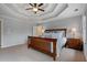 Spacious bedroom boasts a tray ceiling, a ceiling fan, and a king bed with decorative pillows at 5292 Candleberry Sw Dr, Lilburn, GA 30047