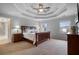 Spacious bedroom boasts a tray ceiling, a ceiling fan, and a king bed with decorative pillows at 5292 Candleberry Sw Dr, Lilburn, GA 30047