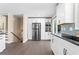 Modern kitchen with stainless steel refrigerator, white cabinets, black countertops and views to the staircase at 5403 Woodberry Cir, Marietta, GA 30068