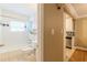 Bright bathroom featuring a tiled tub, toilet, and a glimpse of the kitchen area at 885 Briarcliff Ne Rd # D3, Atlanta, GA 30306