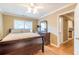 A cozy bedroom featuring wood floors, a ceiling fan, and a view into the en-suite bathroom and hallway at 885 Briarcliff Ne Rd # D3, Atlanta, GA 30306
