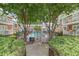 View of a fenced community pool area with lounge chairs and tables, surrounded by mature trees and green landscaping at 885 Briarcliff Ne Rd # D3, Atlanta, GA 30306