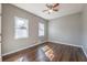 Bedroom featuring hardwood floors, two windows, and modern ceiling fan at 2102 Lenoa Ln, Austell, GA 30106