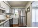 Updated kitchen featuring stainless steel refrigerator, granite countertops, and gray cabinets at 2102 Lenoa Ln, Austell, GA 30106