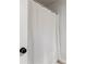 This bathroom features a decorative white shower curtain with a black doorknob in a neutrally painted room at 2286 Cadenza Cir, Dacula, GA 30019