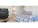 Bedroom showcasing a gaming chair, bed with plaid bedding, dresser, and a view to a bright bathroom and hallway at 2286 Cadenza Cir, Dacula, GA 30019