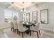 Dining room with coffered ceiling, modern chandelier, a table for eight and three decorative mirrors at 2286 Cadenza Cir, Dacula, GA 30019