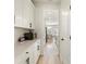 Pantry with white cabinetry and laminate flooring with a view to the kitchen and dining room at 2286 Cadenza Cir, Dacula, GA 30019