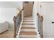 Staircase with wood stairs and railings and black spindles at 2286 Cadenza Cir, Dacula, GA 30019