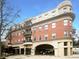 Elegant red brick condo building featuring covered parking and charming balconies on a sunny day at 560 Dutch Valley Ne Rd # 2301, Atlanta, GA 30324
