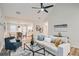 Bright living room with vaulted ceiling, ceiling fan, modern furniture, and decor leading into the adjacent kitchen and dining area at 1493 Buckeye Ter, Auburn, GA 30011